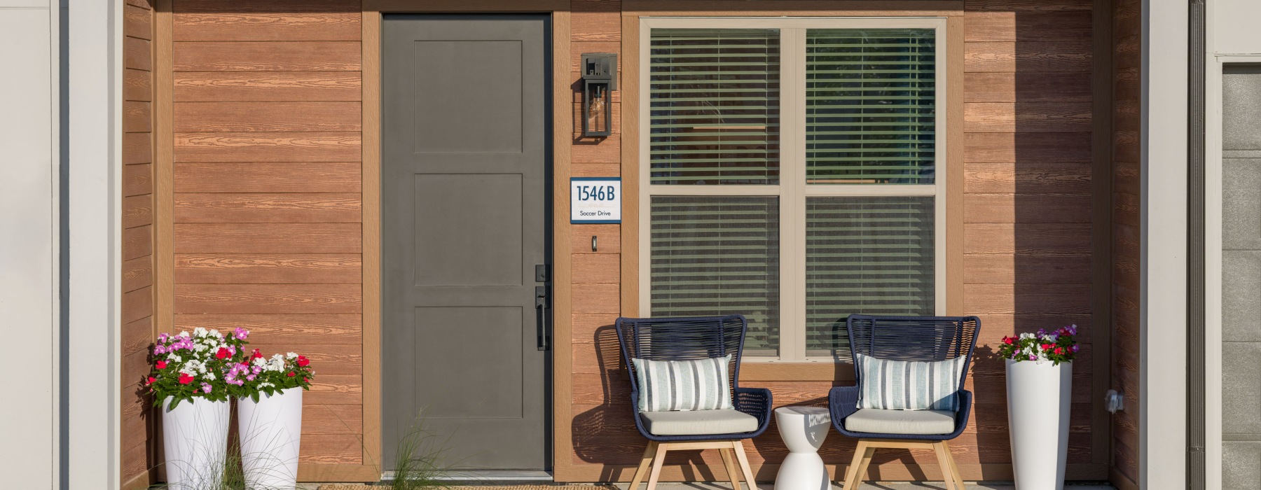 out front of luxury rental home with front door and plants and seating